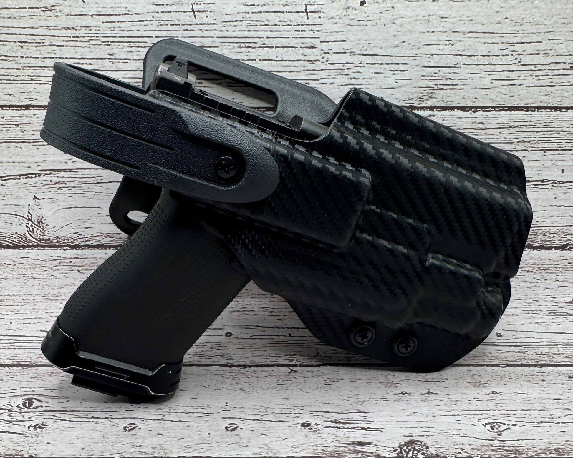 Black firearm holster on a textured light gray surface